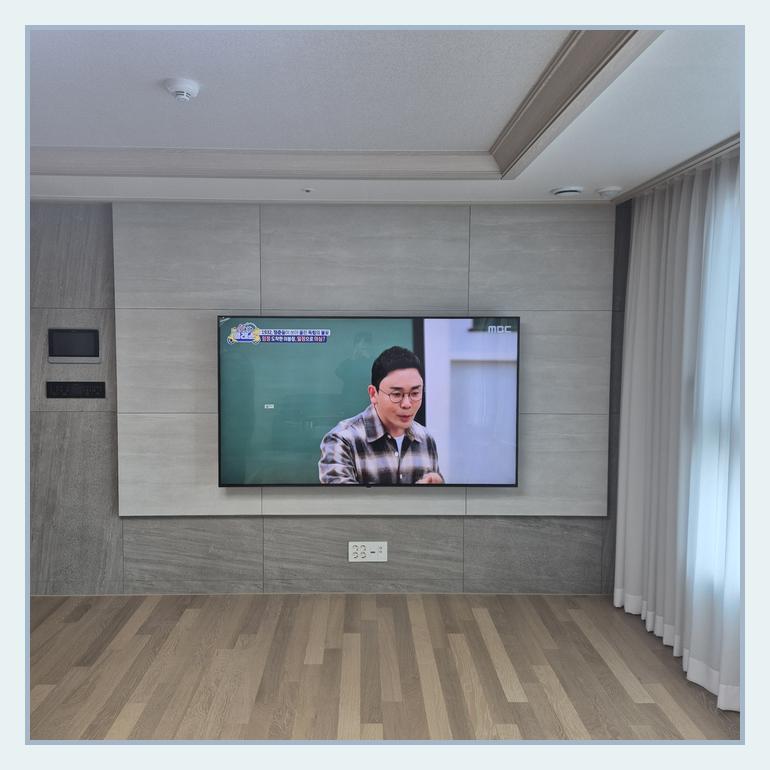 측면 여백과 콘센트 접근성을 검토하는 TV 설치 사진 · 용인 브라켓 확인