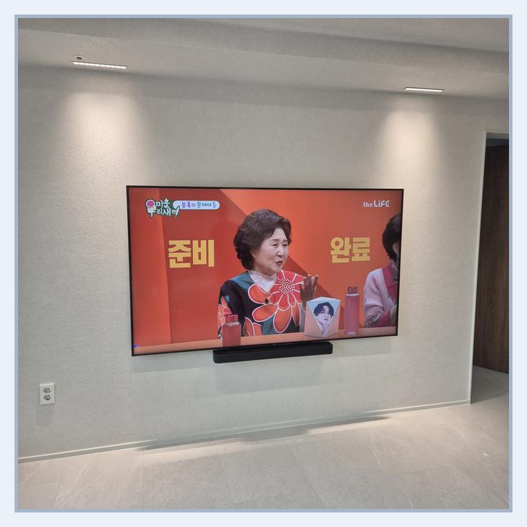 가구 배치와 화면 폭을 함께 비교하는 실제 TV 사진 · 수지 브라켓 확인