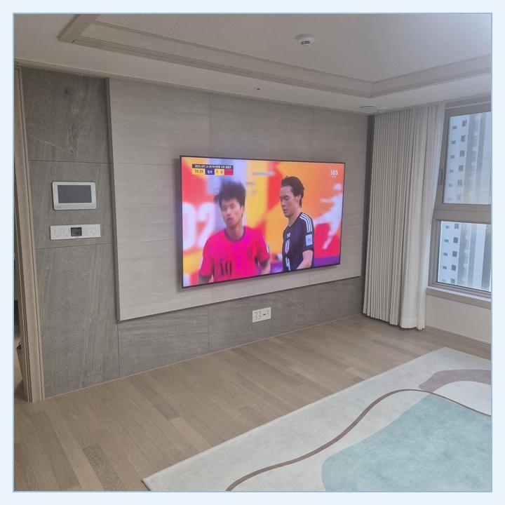 측면 여백과 콘센트 접근성을 검토하는 TV 설치 사진 · 남동 설치 위치